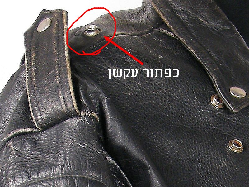 כפתור תקוע וחלוד בכותפת של מעיל עור הארלי דיווידסון וינטג’ משנות ה־80 לפני השחזור.