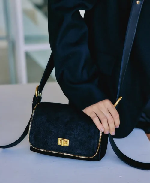 תיק צד עור לנשים אגנס קטן שחור עם רוכסן ומנעול מוזהב על דוגמנית