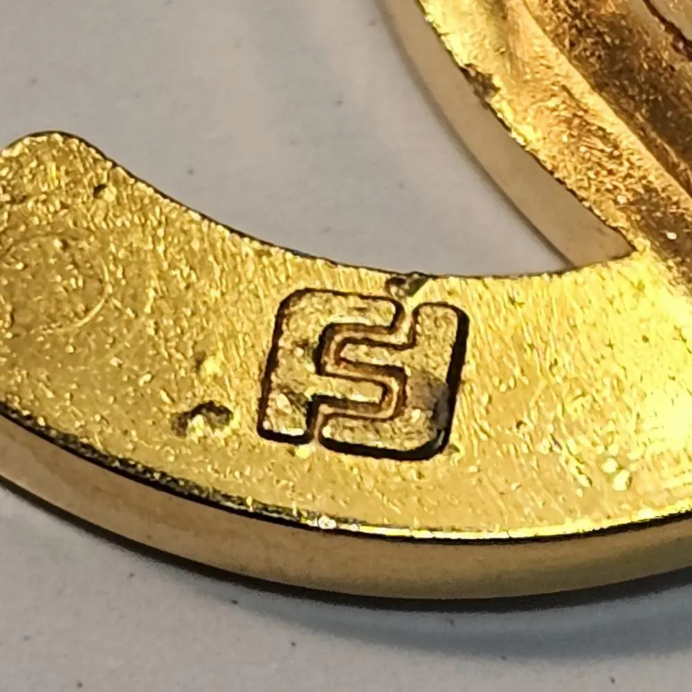 Macro close-up of FA factory marking on authentic Chanel CC lock hardware