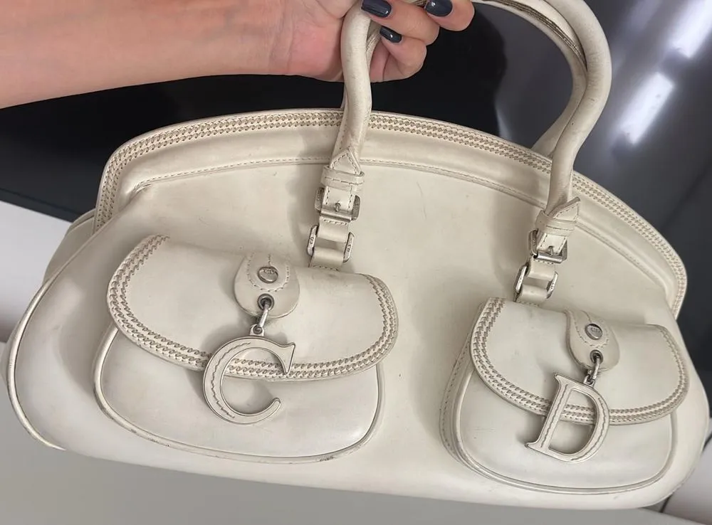 תיק Dior לפני שיקום – חזית התיק עם סימני לכלוך, שחיקה ושינויי גוון בעור