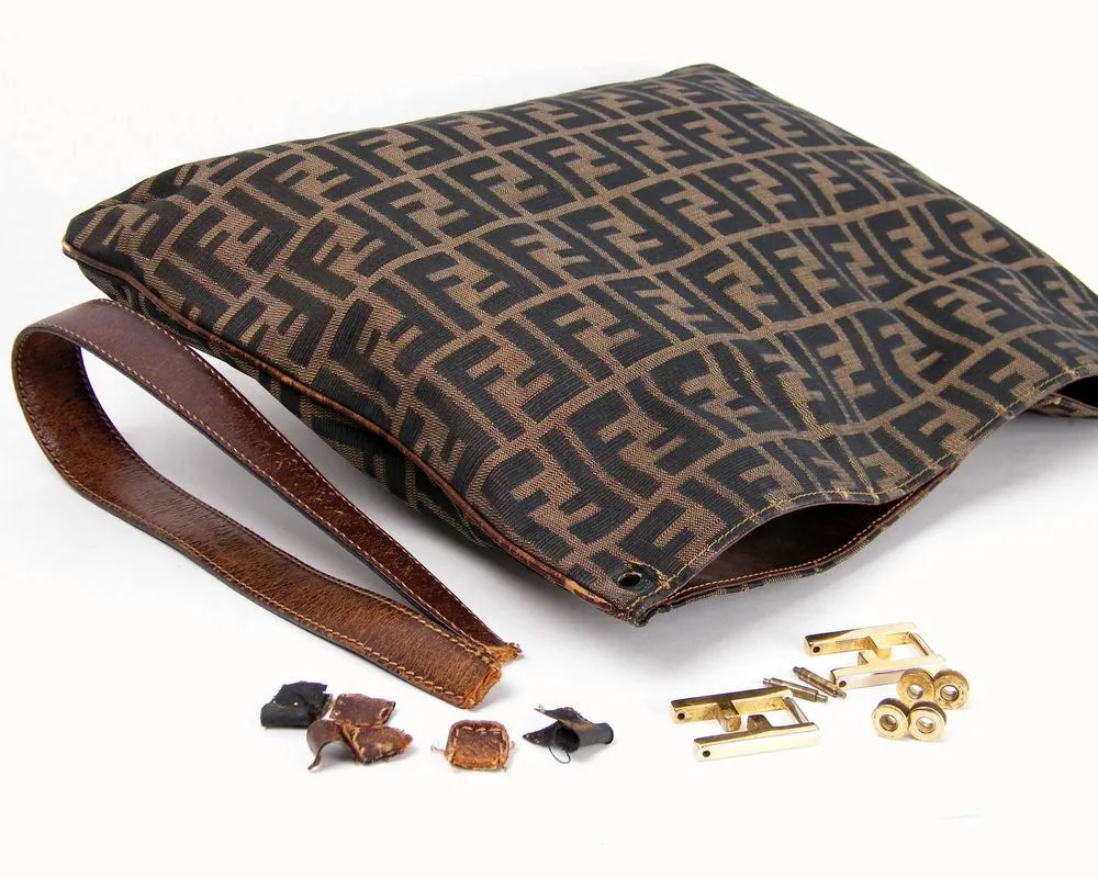 Disassembled Fendi Zucca bag before leather strap restoration and hardware refurbishment