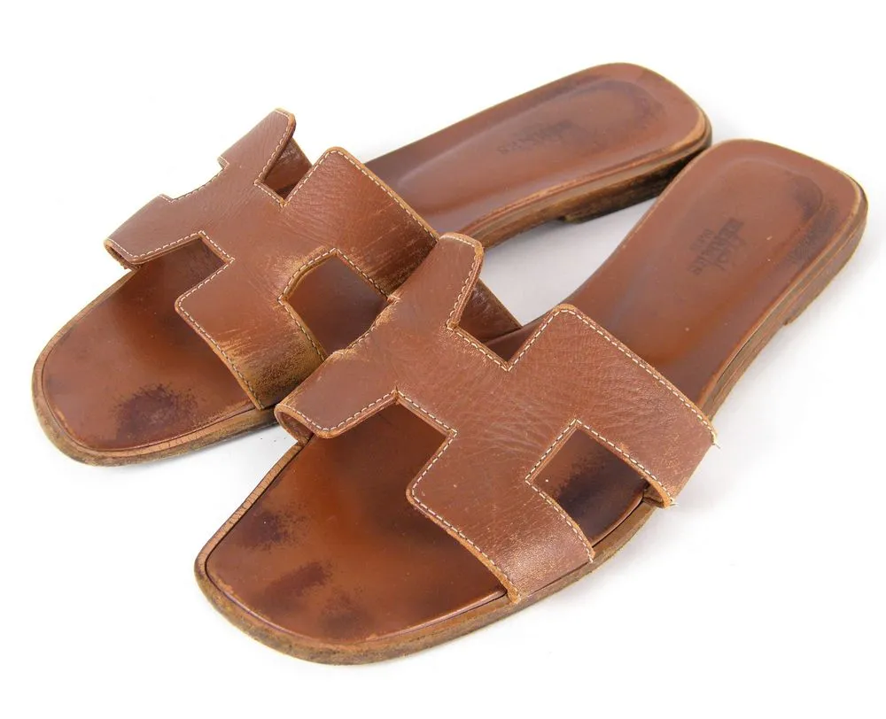 סנדלי Hermès Oran חומים כפי שהגיעו לסטודיו עם שחיקה, כתמים ודהיית צבע