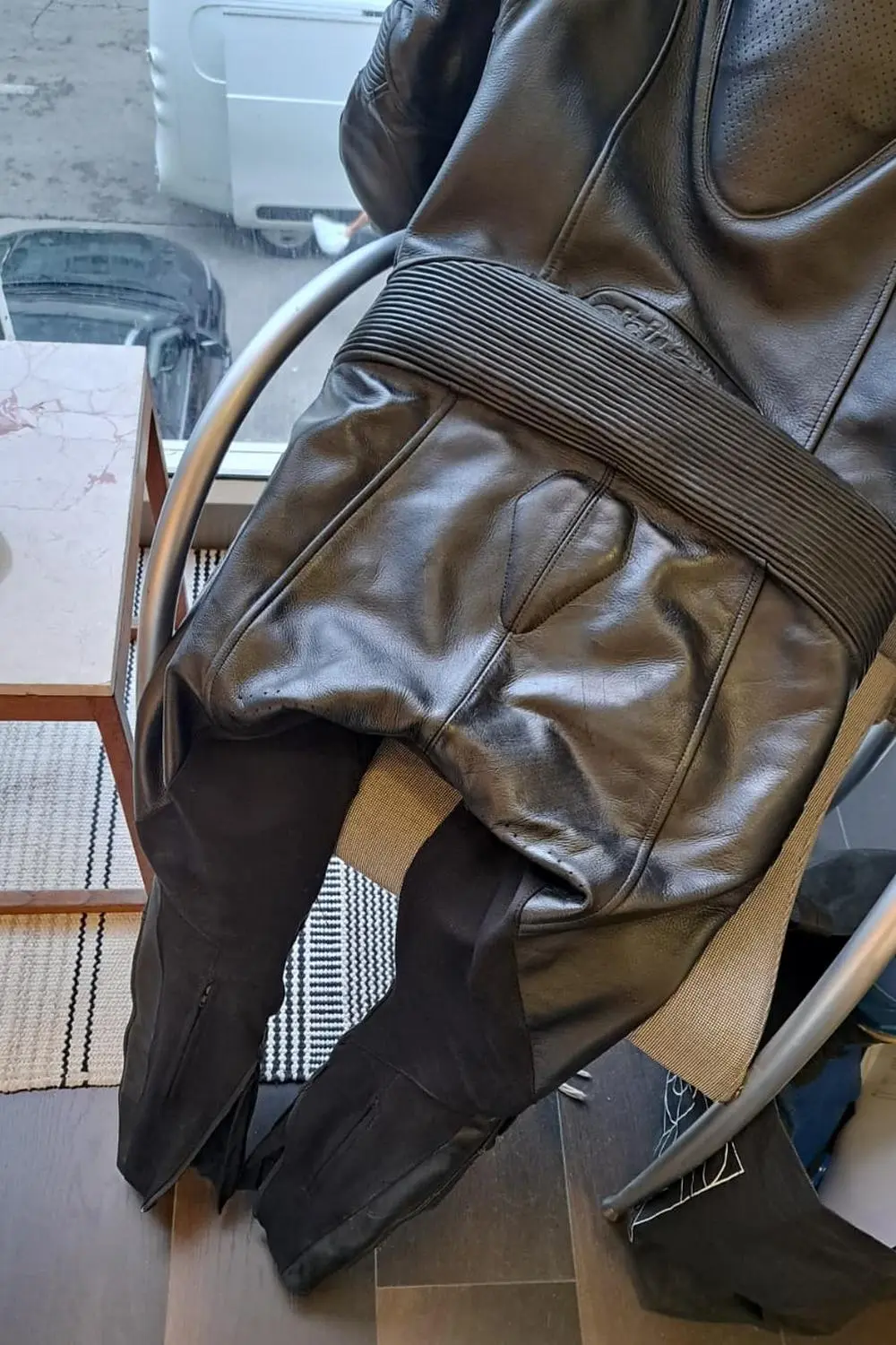 חליפת רכיבה מעור שחור לאחר טיפול וחידוש העור באזור הישבן