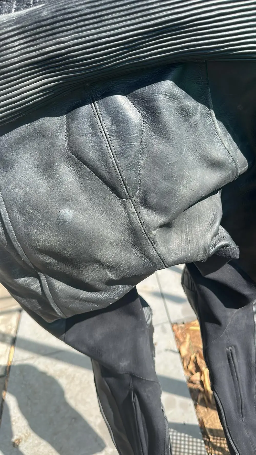 עור שחוק ודהוי באזור הישבן בחליפת רכיבה מקצועית לפני שיקום